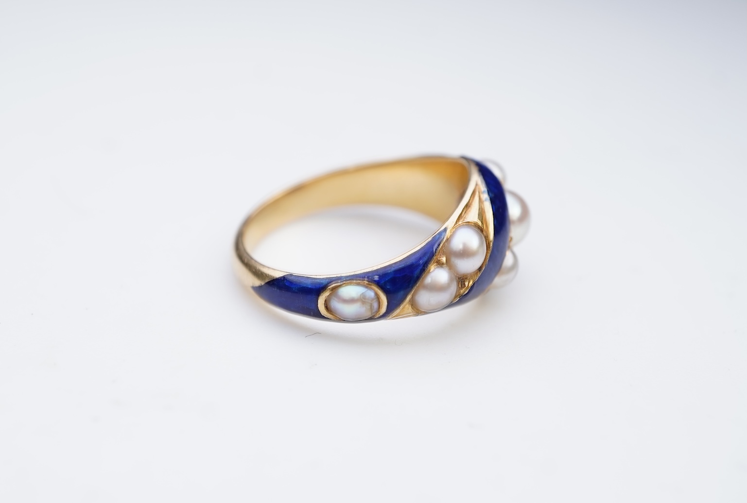 A Victorian half pearl and blue enamel ring, mid 19th century